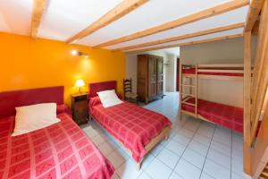 twee bedden in een kamer met gele muren bij Domaine Saint Julien in Buis-les-Baronnies