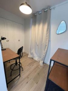 een kamer met een bureau, een tafel en een stoel bij Appartement proche Stade/Eurexpo in Décines-Charpieu