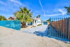 um portão azul em frente a uma casa com palmeiras em New!Palm Springs Windmill Villa-Pool/Spa/Golf/View em North Palm Springs