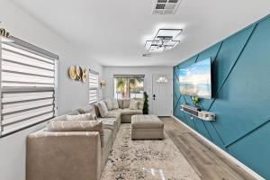 uma sala de estar com um sofá e uma televisão de ecrã plano em New!Palm Springs Windmill Villa-Pool/Spa/Golf/View em North Palm Springs