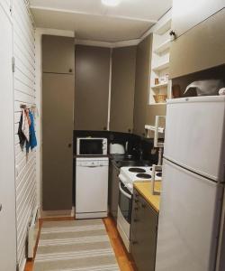 uma cozinha com um frigorífico branco e um fogão em Aslak Apartment em Saariselka