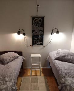 een slaapkamer met 2 bedden, een kruk en 2 verlichting bij Aslak Apartment in Saariselkä