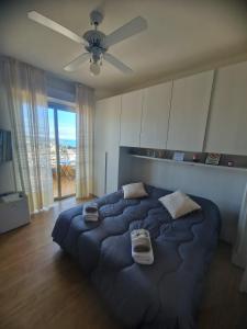 a large bed in a bedroom with a ceiling fan at Il Paradiso del Relax Chambres d'hotes Affittacamere room with sea view in Sanremo