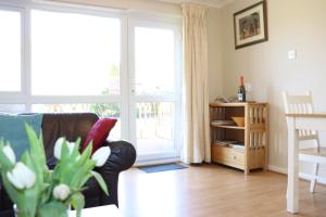 a living room with a couch and a table and a window at Corton Retreats At Waterside Park in Corton