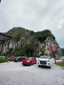 um grupo de carros estacionados em frente a uma montanha em MinAn Homestay Gua Musang (no tv no wifi) em Gua Musang