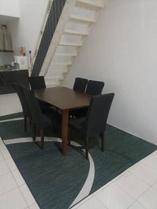 a dining room table with chairs and a staircase at MinAn Homestay Gua Musang (no tv no wifi) in Gua Musang