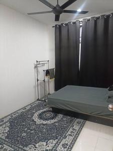 a bedroom with a bed with a black curtain and a rug at MinAn Homestay Gua Musang (no tv no wifi) in Gua Musang