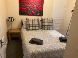 a bedroom with a bed and a painting of red tulips at 103 Nelson Street 1 st floor Right in Largs