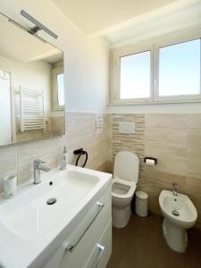 a white bathroom with a sink and a toilet at Bibbi's House San Lorenzo in Rome