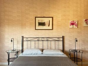 a bedroom with a bed with two tables and a picture on the wall at Bibbi's House San Lorenzo in Rome