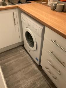 a washing machine in a kitchen under a counter at 103 Nelson Street 1 st floor Right in Largs