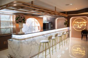 bar z marmurowym blatem i stołkami w obiekcie Siri Grand Bangkok Hotel w mieście Bangkok