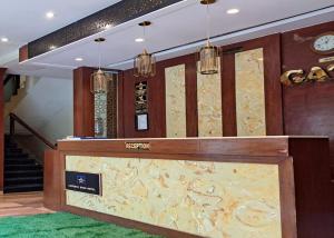 a lobby with a reception desk and a staircase at GATEWAY STAR HOTEL in Mumbai