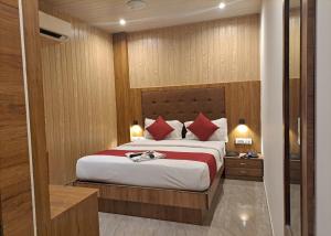 a bedroom with a large bed with red pillows at GATEWAY STAR HOTEL in Mumbai