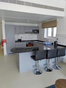 a kitchen with a counter and two bar stools at as sifah in Muscat