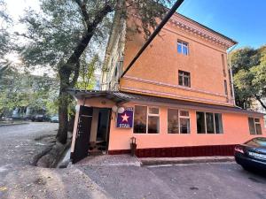 ein kleines rosa Gebäude mit einem Stern darauf in der Unterkunft STAR in Almaty