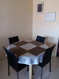 a table with two chairs and a tablecloth on it at October Homes, One Oasis Ortigas in Manila