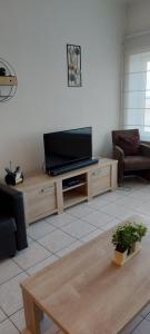 a living room with a television on a wooden entertainment center at Residentie GALAXY in Middelkerke