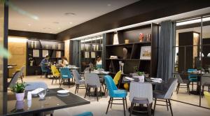 a restaurant with tables and chairs and people sitting at tables at Intelier Rosa in Castellón de la Plana