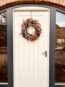 a white door with a wreath on it at Contemporary Luxury Barn Conversion in County Durham in Durham