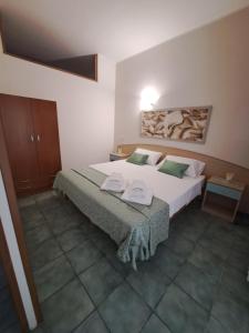 sypialnia z dużym białym łóżkiem z zielonymi poduszkami w obiekcie Depa Holidays w mieście Lizzanello