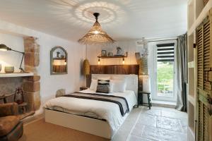 sypialnia z łóżkiem i żyrandolem w obiekcie Ferme Elhorga w Saint-Pée-sur-Nivelle