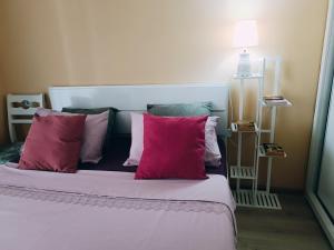een slaapkamer met een bed met roze kussens bij Vake Residence cloze to Park Mziuri in Tbilisi City