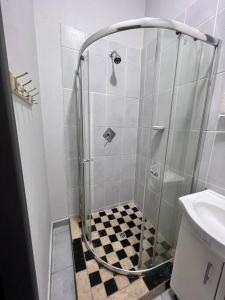 een douche in een badkamer met een geruite vloer bij La Creme Waterkloof 2 in Pretoria