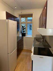 een keuken met een witte koelkast en een wastafel bij Cosy apartment in city centre in Bergen