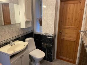 een badkamer met een toilet, een wastafel en een spiegel bij Cosy apartment in city centre in Bergen
