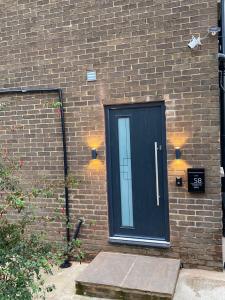 a black door on the side of a brick building at Harmony home Lindley Huddersfield in Lindley
