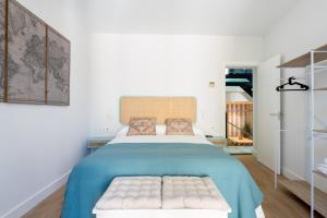 a bedroom with a large bed with a blue blanket at Santa Barbara Central Suites, Sevilla in Seville