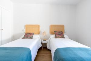 two beds sitting next to each other in a room at Santa Barbara Central Suites, Sevilla in Seville