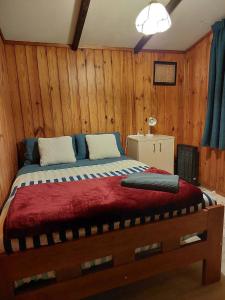 - une chambre avec un grand lit et des murs en bois dans l'établissement Sister’s place, à Auckland