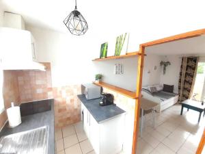 Le Cocouning في Ceyras: مطبخ وغرفة معيشة مع طاولة وأريكة