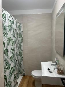 een badkamer met een toilet en een douchegordijn bij Casa Coralia 