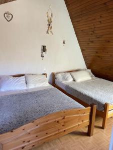a bedroom with two beds and a clock on the wall at Chalet cosy-vue sur la montagne & montgolfières in Saillagouse