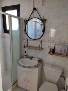 a bathroom with a sink and a toilet and a mirror at Chalet cosy-vue sur la montagne & montgolfières in Saillagouse