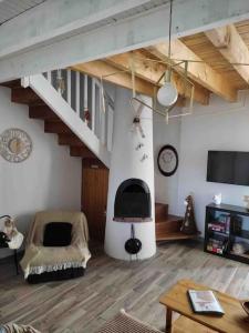 a living room with a staircase and a fireplace at Chalet cosy-vue sur la montagne & montgolfières in Saillagouse