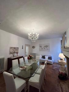 a dining room with a glass table and white chairs at A un passo dal castello in Pacentro