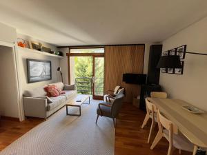 ein Wohnzimmer mit einem Sofa und einem Tisch in der Unterkunft Tuca - Apartamento acogedor con garaje a 1 km de Vielha in Vielha e Mijaran