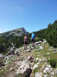 deux personnes sont debout sur une montagne rocheuse dans l'établissement Turistična Kmetija Zgornji Zavratnik, à Luče