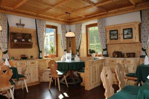 una cocina con armarios de madera, mesa y sillas en Gasthaus Marie, en Achenkirch