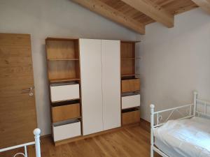 - une chambre avec un lit et un placard avec des étagères dans l'établissement Villa Mountainview, à Bludenz