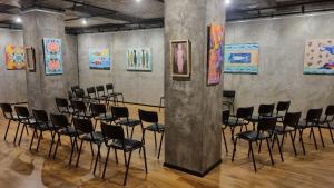 - un groupe de chaises dans une pièce ornée de peintures dans l'établissement Art Hotel 158, à Sofia