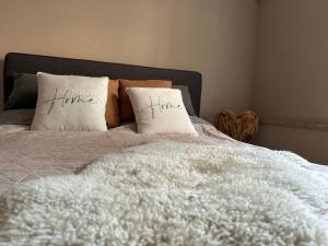 a bed with two pillows with the words let your time true at Kleine Auszeit in Viersen