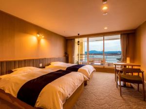 Habitación de hotel con 2 camas y ventana en Yukai Resort Premium Shirahama Gyoen, en Shirahama
