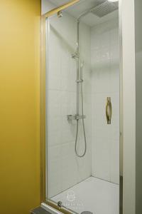 um chuveiro com uma porta de vidro na casa de banho em Spa Niagara privé avec jacuzzi em Herstal
