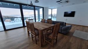 a dining room with a table and chairs and a couch at Luxusní apartmány Čerťák in Vaclavov u Bruntalu