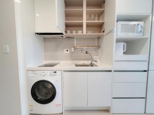 a white kitchen with a washing machine and a sink at Dahlbit stay in Incheon +13 photos